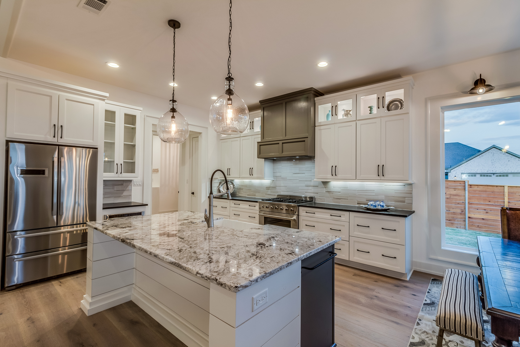 Granite countertops and two pendant lights above island
